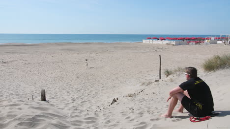 Mann-Spielt-Mit-Seinem-Hund-An-Einem-Sandstrand-In-Sete,-Frankreich